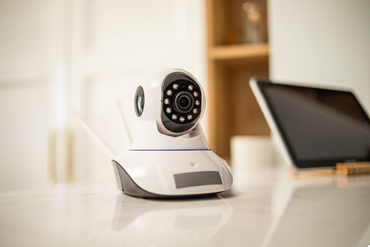 A white security camera positioned on a counter, ready to monitor the surroundings effectively.