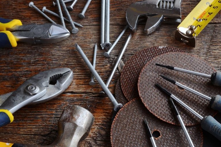 Tools laid out on a wooden table, showcasing a ruler, pliers, and other essential instruments for DIY projects.